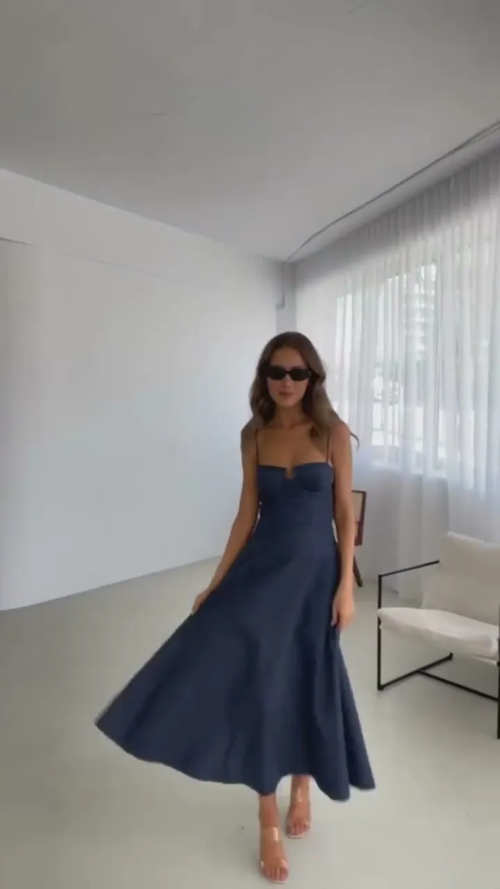 Nataša Milisic moving through a bright studio in a navy dress